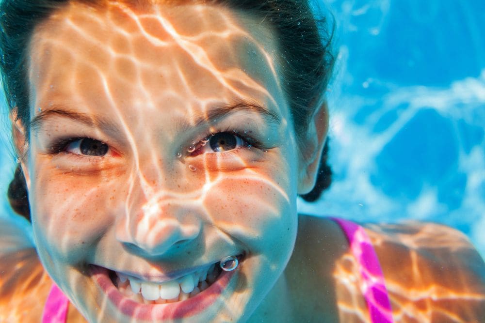 Djevojčica pliva pod vodom otvorenih očiju